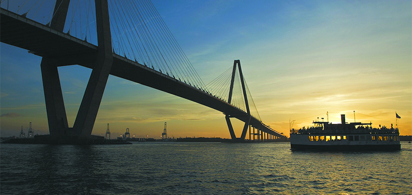 The Carolina Belle slips under the Ravenel Bridge at sunset.